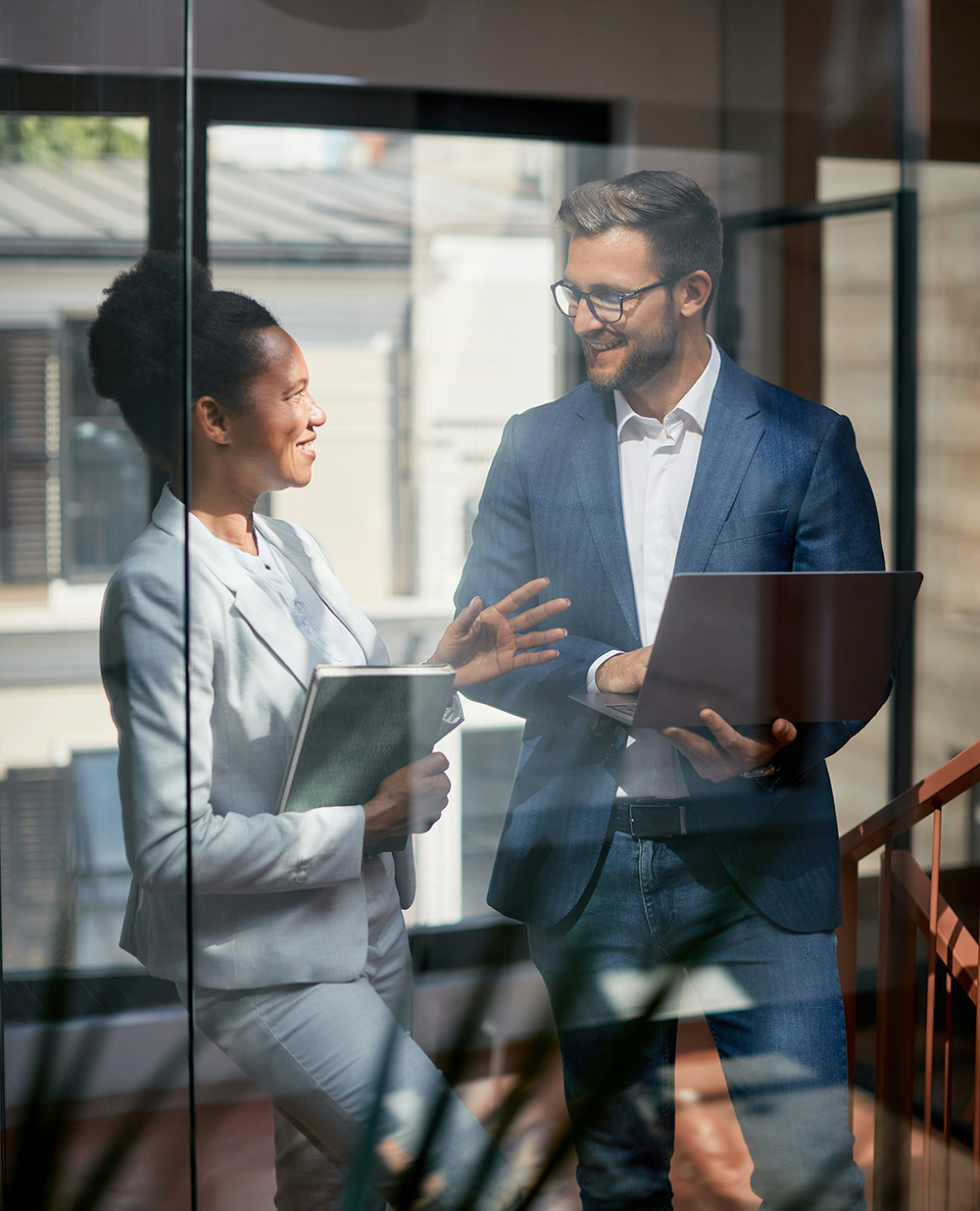 two business people talking behind an office window