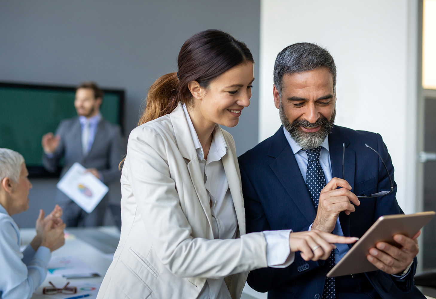 businesswoman and man looking at a tablet at work